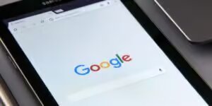 Imagen de una tablet con la palabra Google en un fondo blanco con un fondo trasero metalico de color gris.