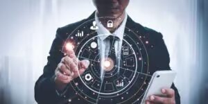 Hombre con traje y corbata tecleando una pantalla tactil invisible con logotipos tecnologicos futuristas de un candado y un gráfico mientras sostiene un smartphone de los negocios digitales por BarmetMedia.