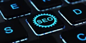 Tecla con la palabra SEO dentro de un engranaje para comprar enlaces para mejorar el posicionamiento web: ventajas, riesgos y cómo hacerlo correctamente con BarmetMedia.