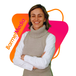 Beatriz Pérez con camisa blanca y jersey beige delante del logotipo minimalista moderno rosa y naranja de BarmetMedia.