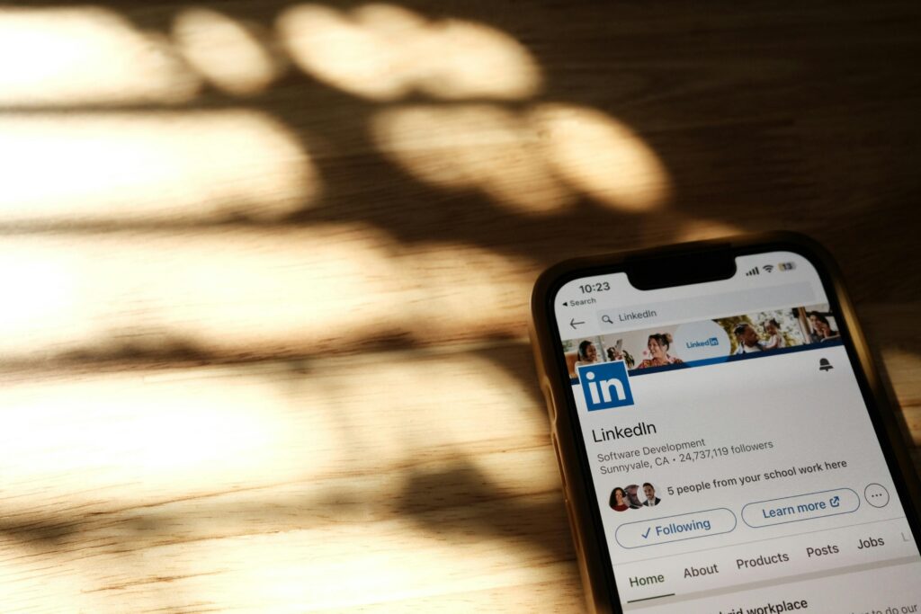 Teléfono con LinkedIn abierto de fondo