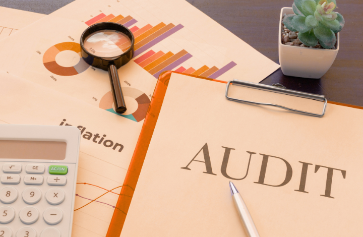 Documentos con gráficos, lupa y carpeta de auditoría sobre una mesa, representando un análisis SEO y de rendimiento web